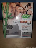 Front box image showing Conair Eco Therapy Body Benefits muscle relief pads, highlighting hot and cold therapy, natural bamboo fabric, and microwaveable/freezable features