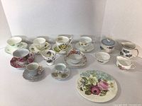 Full view of all bone china tea set items including cups, saucers, creamers, sugar bowls, and side plate.