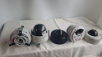 Front view of five dome security cameras on a white fabric surface, showing varied dome shapes and mounting setups.