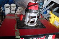 Freud router mounted on the router table with red surface showing wear and tape marks.