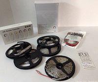 Photo of six reels of LED strip lights of varying amounts, two boxed LTECH LED remote controllers, and package of bare lead adapters