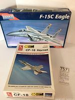 Box of Monogram F-15C Eagle model kit and box of Hobby Craft CF-18 Hornet model kit displayed side by side showing brand names and artwork.