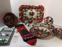 Overview photo of all vintage Christmas items including tray, trivet, napkin holder, basket, shakers, stocking, plates, and figurines.