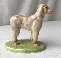 Front and side view showing the dog figurine with naturalistic cream and brown glaze on green base with text "CHAMPIONSHIP SERIES".