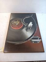 Frontal photo showing the full framed poster with the vintage Pathé record and tonearm design.