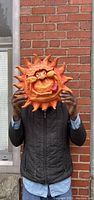 Front view of the rubber plush sun wall hanging with a whimsical face featuring a tongue sticking out.