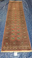 Full length view of the Indo Bokhara runner rug showing the overall pattern and condition on blue tarp.