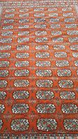 Close-up of repeating gul motifs on orange field