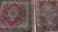 Close-up of the two oriental area rugs showcasing pattern details and fringed edges.