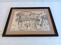 Framed pen and ink drawing featuring a detailed architectural scene of buildings and a balcony, signed by Florakis in 1964.