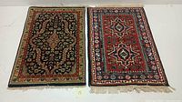 Two hand knotted Persian area rugs side by side showing full patterns and fringes on a white background.