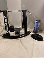 Side view of the Giant bike trainer frame with Tacx tire box and front wheel riser block on the side.