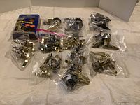 Assorted door locks and handles in original packaging and sealed plastic, showing variety of finishes and styles including brass and chrome.