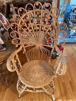 Front view of the peacock style bamboo and wicker chair showing its intricate scroll and woven seat.