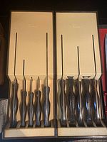 Two Cutco wall-mount cases, each holding five black-handled knives.