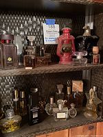 Wide view of shelf with assorted perfume and cologne bottles, showing variety of sizes and fill levels.