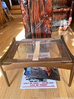 Front angled view of the midcentury modern style bedside table showing the clear insert on top and tapered legs.