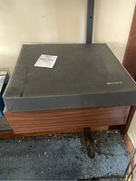 Top view of vintage Sony stereo system with black cover and wood panel sides, showing some dust and wear.