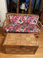 Vintage wicker bench with floral cushions and wicker storage table in front