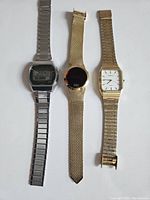 Photo shows three vintage watches side by side: Timex LED digital watch with silver band, gold-tone mesh band analog watch with black face, and Caravelle analog watch with gold-tone expandable band.