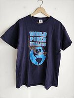 Front view of black vintage 1995 World Poker Finals T-shirt with graphic of globe and text 'WORLD POKER FINALS 1995'.