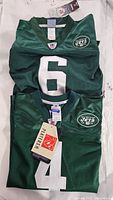 Two New York Jets green football jerseys with numbers 6 and 4, NFL and Jets logos, new with tags, kids small