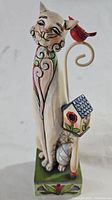 Full view of Jim Shore Tilly Cat figurine showing cat, curled tail with bird and birdhouse, and base.