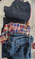 Assorted pants folded, including plaid and sweatpants