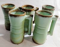 Five vintage Frankoma juice cups shown from side angle to display shape and handles.
