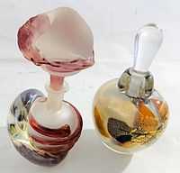 Pair of art glass perfume bottles with distinctive colorful glass patterns and unique stopper designs.