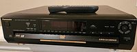 Front view of the Panasonic DVD-CV51 DVD/CD player with remote on top showing branding and disc changer slot.