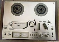 Full top view of the Akai GX-4000DB showing dual tape reels, control knobs, switches, and VU meters