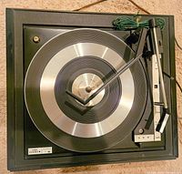 Top view of vintage Fisher automatic record player showing platter, tonearm and control lever.