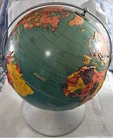 Photo showing the globe from a tilted angle capturing countries near the Atlantic Ocean including parts of South America, Africa, and Europe. Shows the clear plastic base and meridian supporting the globe.