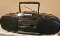 Front view of RCA RP-7946A vintage boombox with speakers, handle, and antenna visible.