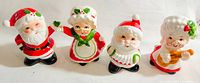 Front view of the four ceramic salt and pepper shakers, featuring two Santa Claus and two Mrs. Claus figures in festive attire with bright colors and detailed painting.