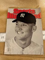 Front cover of Sports Illustrated magazine with black and white image of Mickey Mantle in Yankees cap and uniform, red title text at the top.