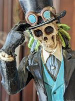 Close up of the Day of the Dead skeleton figurine dressed as a gentleman tipping his top hat showing intricate facial and clothing details.