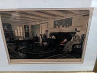 Photo of framed signed vintage style interior scene picture showing two people seated near a fireplace in detailed setting, signed on bottom.