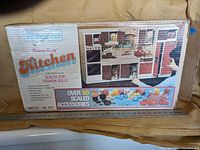 Photo of the box with full front view showing brand, product name and image of the kitchen playset with accessories.