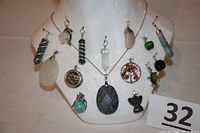 Front view of 15 different natural rock pendants displayed on white bust with 925 sterling silver chain.