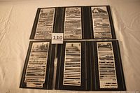 Open view of two black Fotofile albums with photographs mounted on pages