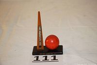 Full view of the 1939 New York World's Fair thermometer souvenir showing the amber Bakelite triangular thermometer and red Perisphere globe on black base.