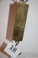 Close-up view of the scale's front, showing black pointer and etched measurement scale 0 to 50 pounds on brass plate.