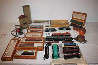 Wide shot of entire lot showing engines, rolling stock, boxed items, structures, and transformer.
