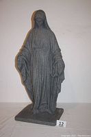 Full view of the large Virgin Mary garden statue showing entire figure and base with granite-like texture.