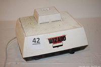 Front perspective of the white Inland Wizard Grinder device showing the brand label and overall shape.