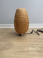 Ikea Boja table lamp unplugged showing woven wicker shade and metal base.