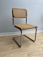 Side view of vintage Cesca style wicker chair showing woven wicker backrest and seat with wood trim and tubular chrome cantilever frame.