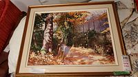 Framed signed painting showing autumn forest landscape with path, detailed leaves, and tall trees.